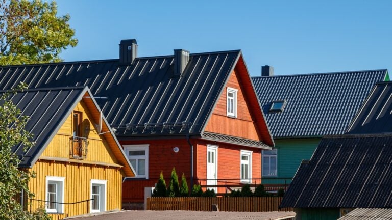 Wooden houses. Classic metal roof. Colorful Houses